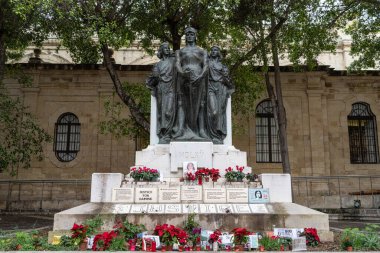 Valletta, Malta - 20 Aralık 2024: 2017 'de öldürülen gazeteci Daphne Caruana Galizia için adalet isteyen Büyük Kuşatma Anıtı' nın tabanına fotoğraflar, mumlar ve mesajlar bırakıldı.
