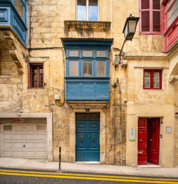 Malta 'da geleneksel ev işleri. Kireçtaşı sarısı tuğlalar ve renkli balkonlar, pencereler
