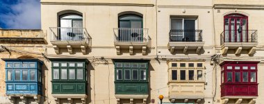 Malta 'da geleneksel ev işleri. Kireçtaşı sarısı tuğlalar ve renkli balkonlar, pencereler