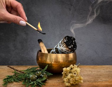 white sage incense and singing bowl in front of white background