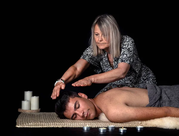 man and energy healing  in front of black background