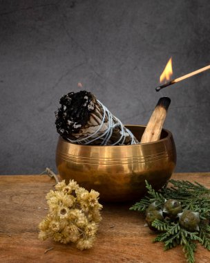 white sage incense and singing bowl in front of white background