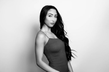 Uzun, parlak siyah saçlı güzel bir kadın. Gülümseyerek poz veriyor.