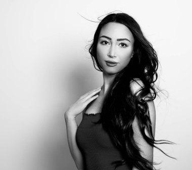 Uzun, parlak siyah saçlı güzel bir kadın. Gülümseyerek poz veriyor.