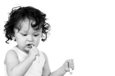 Kıvırcık saçlı bebek diş fırçasıyla dişlerini fırçalıyor.