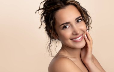 Güzel gülüşü ve derisi pürüzsüz cildiyle güzel genç bir kadın.