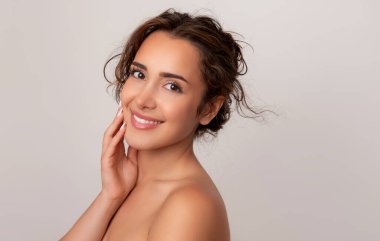 Güzel gülüşü ve derisi pürüzsüz cildiyle güzel genç bir kadın.