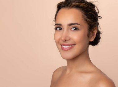 Güzel gülüşü ve derisi pürüzsüz cildiyle güzel genç bir kadın.