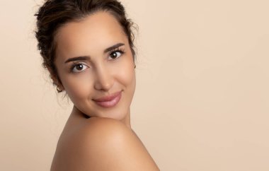 Güzel gülüşü ve derisi pürüzsüz cildiyle güzel genç bir kadın.