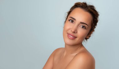 Güzel gülüşü ve derisi pürüzsüz cildiyle güzel genç bir kadın.