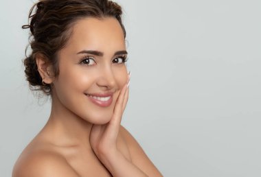 Güzel gülüşü ve derisi pürüzsüz cildiyle güzel genç bir kadın.