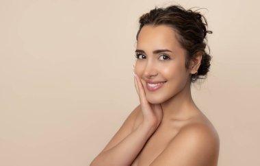 Güzel gülüşü ve derisi pürüzsüz cildiyle güzel genç bir kadın.