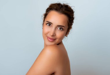 Güzel gülüşü ve derisi pürüzsüz cildiyle güzel genç bir kadın.