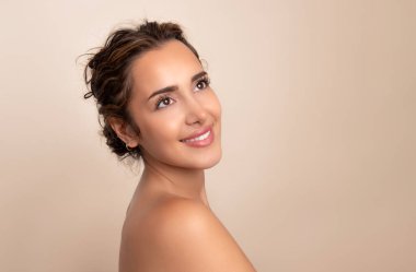 Güzel gülüşü ve derisi pürüzsüz cildiyle güzel genç bir kadın.