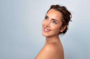 Güzel gülüşü ve derisi pürüzsüz cildiyle güzel genç bir kadın.