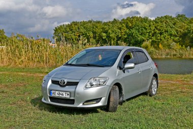 Ukrayna 'nın Dnipropetrovsk bölgesi Novomoskovsk şehri 12 / 10 / 2024. Toyota Auris nehir kıyısındaki arabanın fotoğraf çekimi. Araba öncelikle Avrupalı tüketicileri hedef almakla birlikte, hem Avrupa 'da, hem İngiltere' deki Toyota fabrikalarında ve Japonya 'da üretilmektedir..