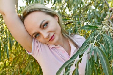 Yazın Ukrayna 'da bir zeytin ağacının arka planında güzel bir kadın.