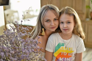 Bir buket güzel sonbahar çiçeğiyle güzel bir anne ve kız..