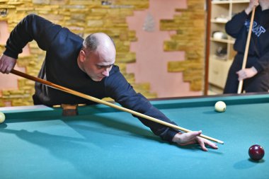 Yetişkin erkek ve kadınlar bir kır evinde Rus bilardosu oynuyorlar. Doğu Ukrayna.