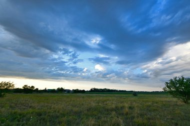 Yaz yağmurundan sonra güzel bir yaz manzarası, gün batımında şehir dışında, köyde. Ukrayna, Dnipropetrovsk bölgesi.