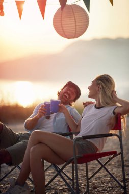 Çiftler gün batımında gülüyorlar, birbirlerine bakıyorlar, kadeh kaldırıyorlar, eğleniyorlar.