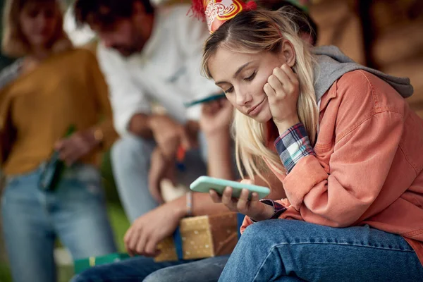 소녀는 현관에서 친구들 축하연을 하면서 스마트폰을 사용하고 있습니다 — 스톡 사진