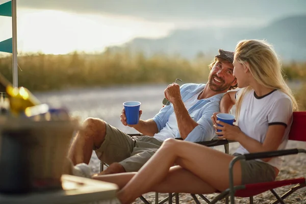 白人の大人のカップルが話して笑顔で お互いを見て 日没に屋外に座って — ストック写真