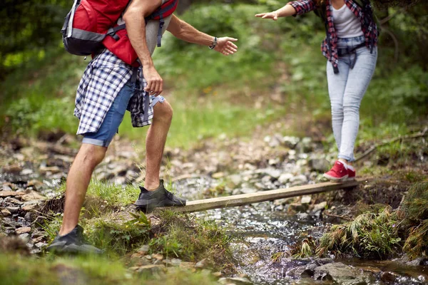 Young Couple Helping Each Other Cross Creek While Hiking Beautiful — Stock Photo, Image