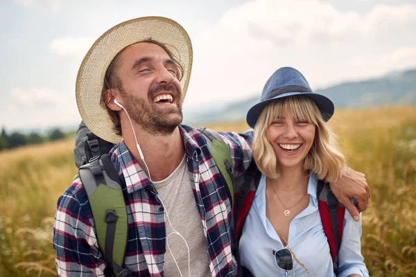 一对笑着的年轻夫妇在乡间远足 玩得很开心 快乐的人们一起在大自然中旅行 — 图库照片