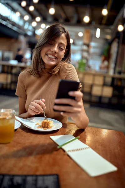 Kafedeki Genç Kadın Telefona Bakıyor Gülümsüyor Neşeli Mutlu Kız Eğleniyor — Stok fotoğraf