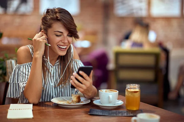 一人でカフェにいる間に友人とのビデオ通話で陽気な若い女性は コーヒーブレイクを楽しんでいます 楽しさ ライフスタイル レジャーのコンセプト — ストック写真