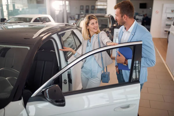 妇女在汽车展示室与汽车销售商购买新车 — 图库照片