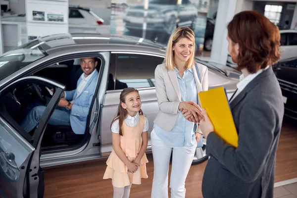 您很高兴您的家人能在汽车发廊里买到新车 — 图库照片
