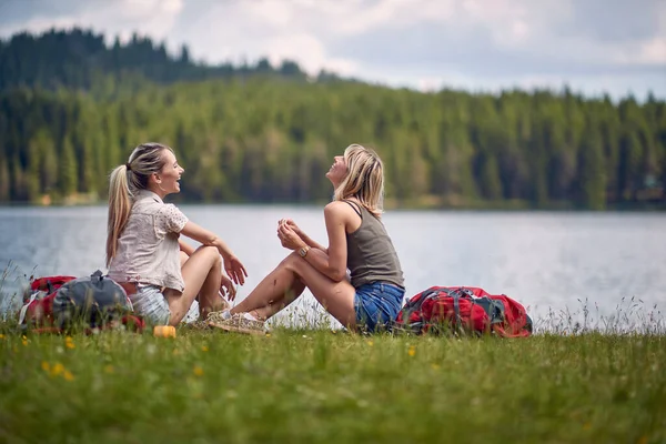 Young Female Friends Sitting Ground Lake While Hiking Hills Beautiful — Stock Photo, Image