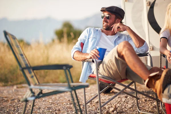 Przystojny Mężczyzna Okularach Przeciwsłonecznych Drinku Siedzący Kamperze Przed Kamperem Patrzący — Zdjęcie stockowe