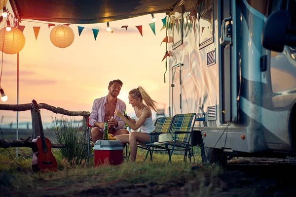 一对年轻夫妇在度假期间坐在营地里 在美丽的落日下度过愉快的时光 — 图库照片