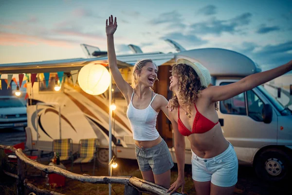 两个年轻性感的女性朋友正在美丽的落日下享受他们在大自然的营地里的假期 — 图库照片