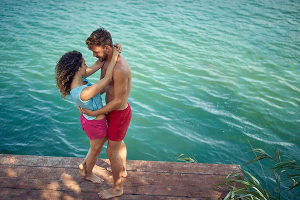 可爱的夫妻拥抱 年轻的男男女女站在水边的木制防波堤上 生活方式的概念 — 图库照片