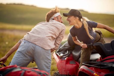 İki mutlu aşık doğada dörtlü araba kullanıyor; aktif tatil konsepti