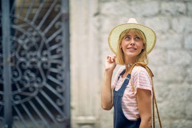 Deniz kıyısında bir tatil sırasında güzel bir günde eski şehre bakan genç bir kızın yakın çekimi. Tatil, deniz kenarı, turist