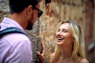 Genç bir çift, deniz kenarında güzel bir günde romantik anların tadını çıkarıyor. Tatil, deniz kenarı, ilişki, turistler