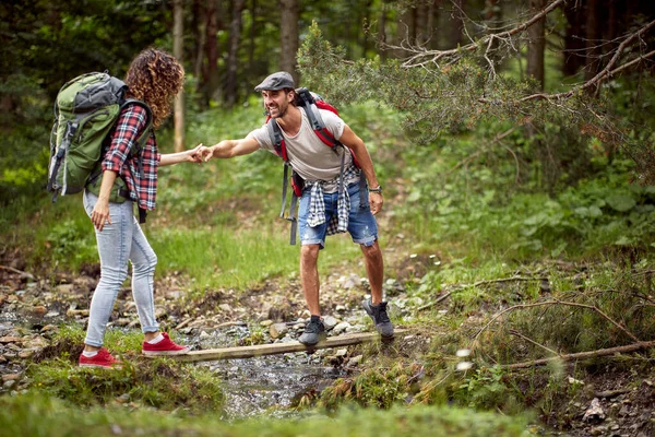 Young Cheerful Couple Carefully Crossing Creek While Hiking Beautiful Day — Stock Photo, Image