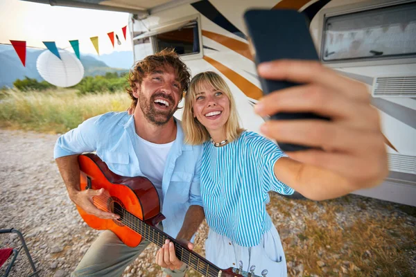 Jovem Casal Está Tirando Uma Selfie Enquanto Toca Guitarra Acampamento — Fotografia de Stock