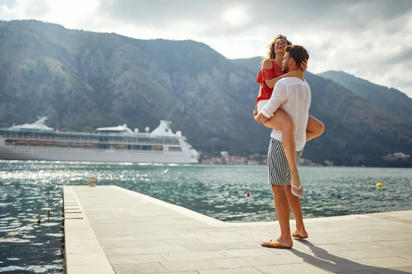一对年轻夫妇在海滨美丽的阳光明媚的一天度假时 热情地拥抱在一起 — 图库照片