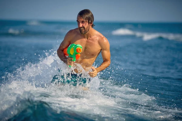 Musculoso Hombre Feliz Jugando Con Pistola Agua Playa — Foto de Stock