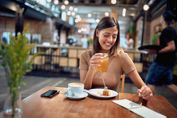 Χαρούμενη Νεαρή Γυναίκα Στην Καφετέρια Απολαμβάνοντας Πρωινό Και Τον Καφέ — Φωτογραφία Αρχείου