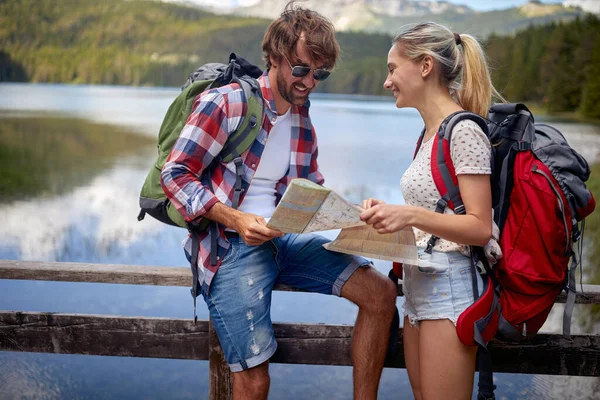 湖の笑顔カップル バックパックを持つカップル観光客屋外 — ストック写真