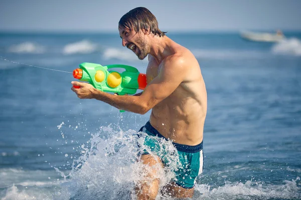 Boldog Ember Játszik Vízipisztollyal Strandon — Stock Fotó