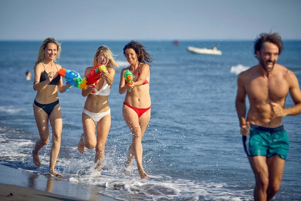 Jóvenes Felices Con Pistolas Agua Divierten Playa Mar — Foto de Stock