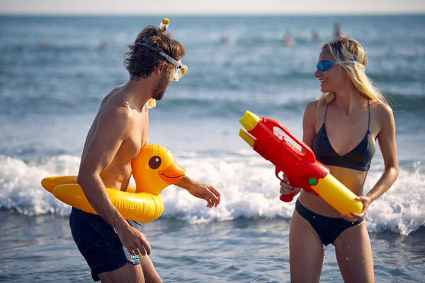 Jóvenes Felices Con Juguetes Acuáticos Divierten Playa Junto Mar —  Fotos de Stock